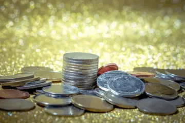 Close-up of gold and silver coins arranged on a table, highlighting their value for buying and selling.